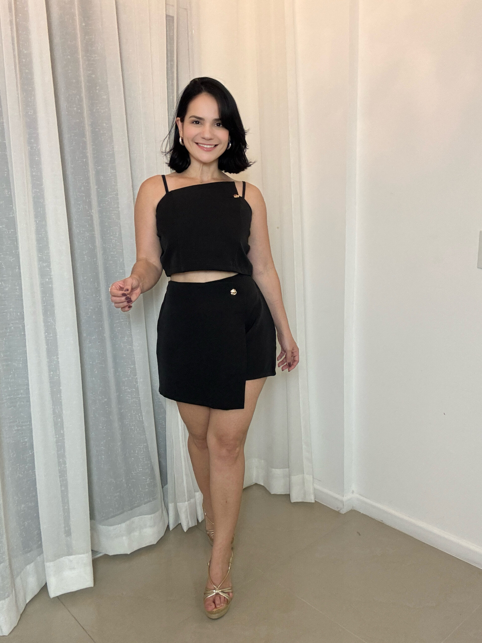 Mulher usando conjunto feminino preto com short saia elegante